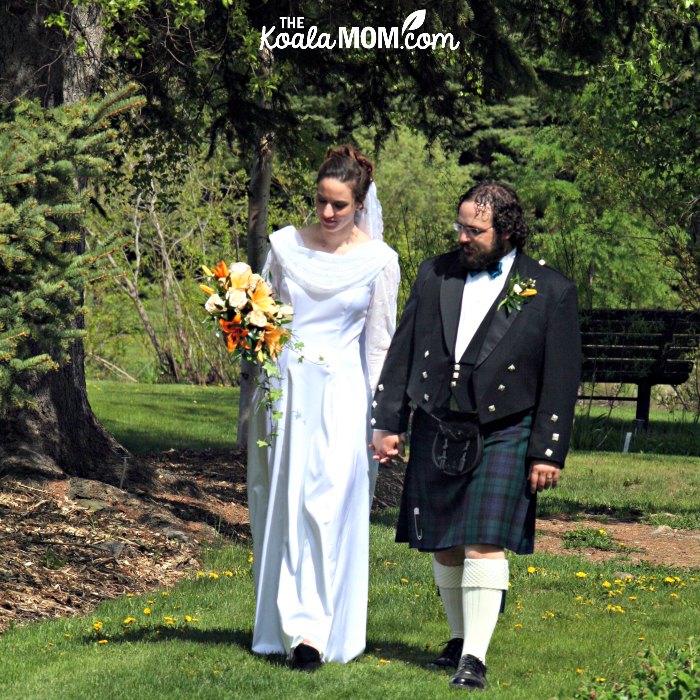 Bride and groom walking through a garden together on their wedding day.