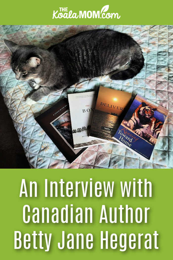 An Interview with Canadian Author Betty Jane Hegerat on Writing. Photo of a grey cat sitting next to Hegerat's four books by Bonnie Way.