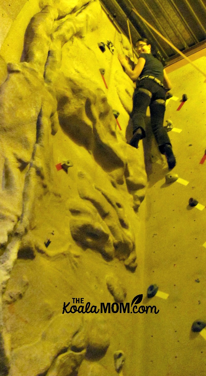 Reaching the top of the rock wall at the climbing gym