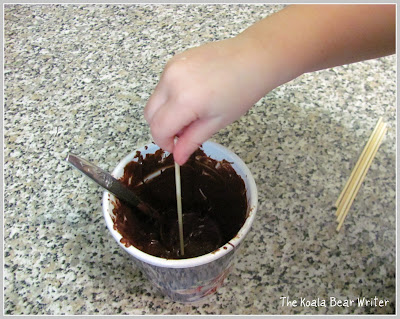 Dipping cake pop balls in melted chocolate