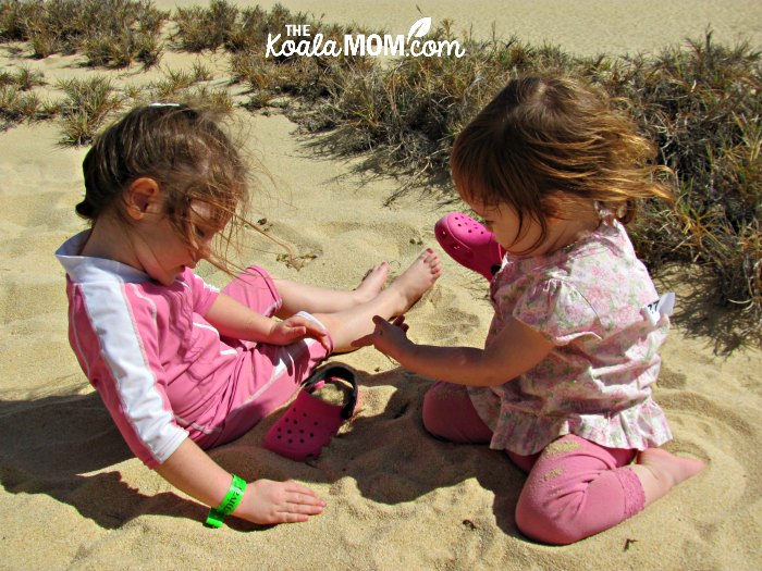 Two girls in pink playing on Lover's Beach in Cabo San Lucas, Mexico.