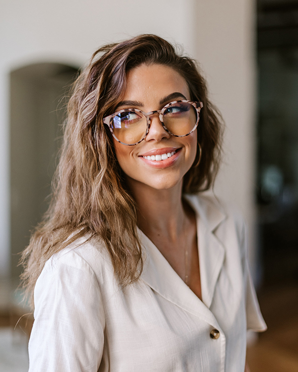 A woman wears trendy glasses she bought online.