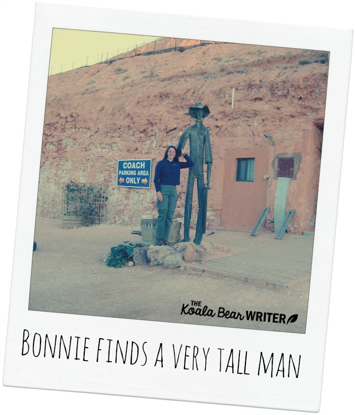 Bonnie with a tall metal man in Coober Pedy, Australia