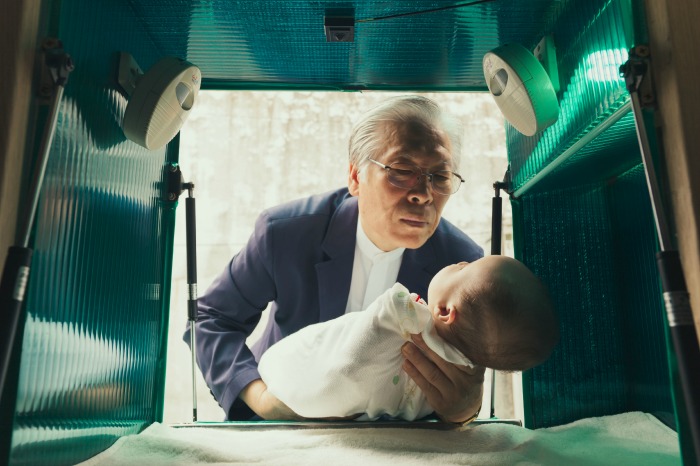 Pastor Lee Jong-rak lifts an abandoned baby from the dropbox outside his home in South Korea.