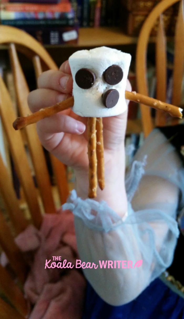 An Olaf snowman made from a marshmallow, chocolate chips and pretzels.