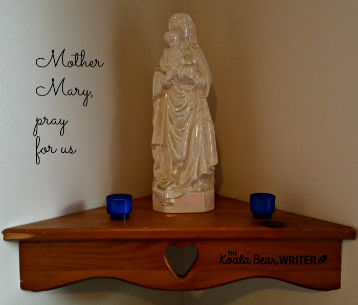 A Mary shrine with a statue and two candles.