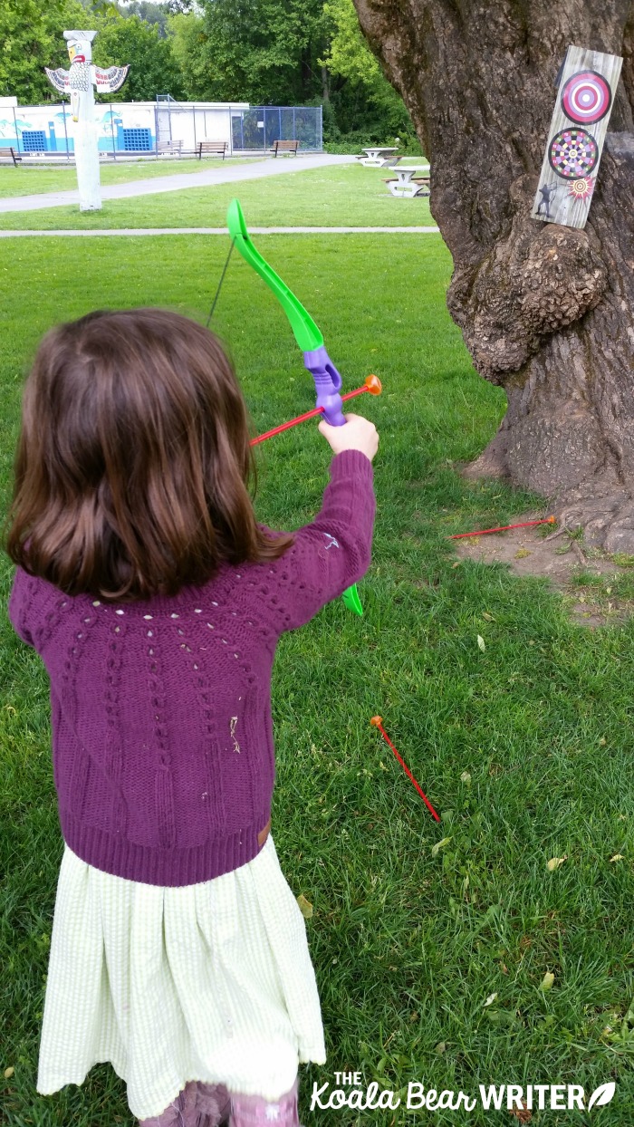 Lily shooting a bow and arrow like Merida in Disney's Brave movie