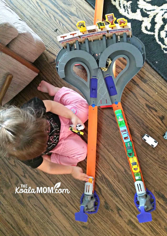 Girls play with the HotWheels car launcher