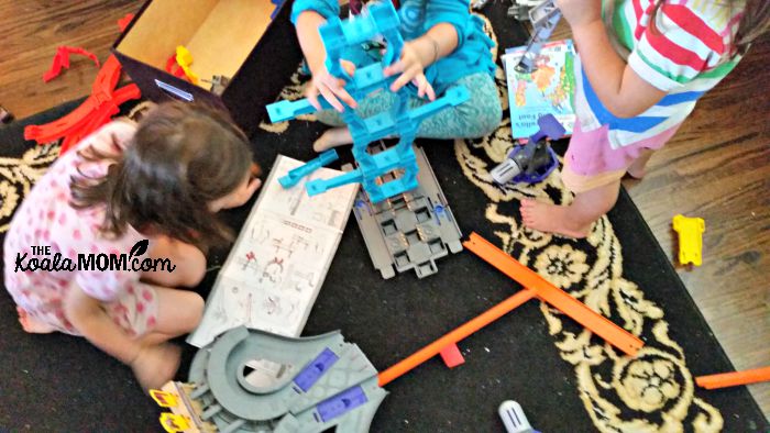 Girls building HotWheels race tracks