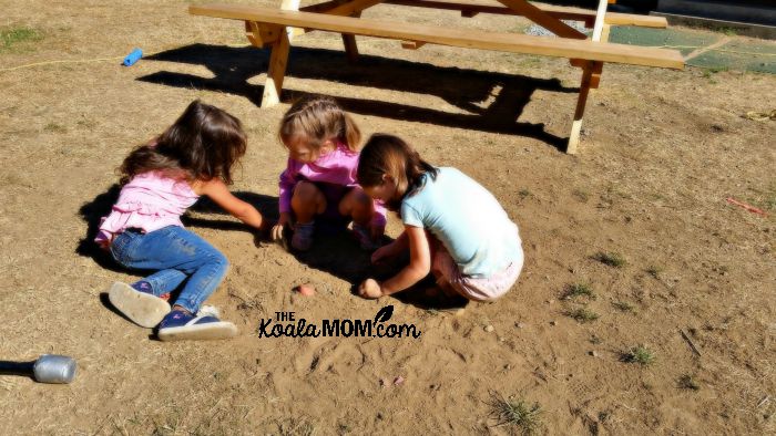 Jade and Lily and a friend playing in the dirt at camp