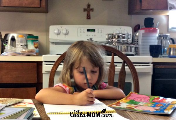 Preschooler writing in a workbook