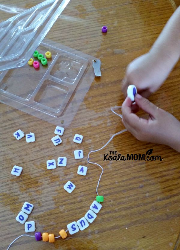 Toddler stringing beads for a bracelet