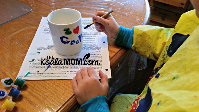 Sunshine painting her mug for Grandpa