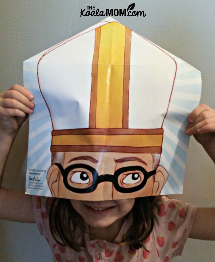 Lily pretends to be Pope Francis with the poster from CCC of America