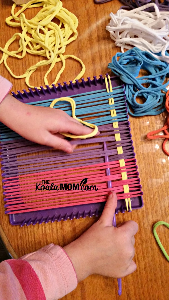 Sunshine weaving her potholder with loom loops