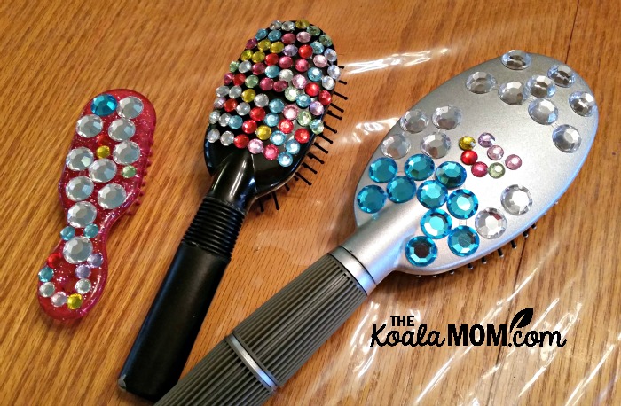 Three rhinestone-decorated hairbrushes