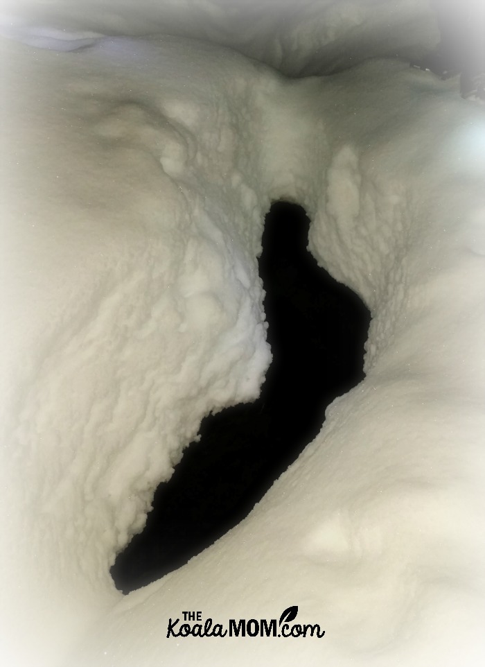 Crevass in the snow with the creek flowing underneath at Cypress Mountain