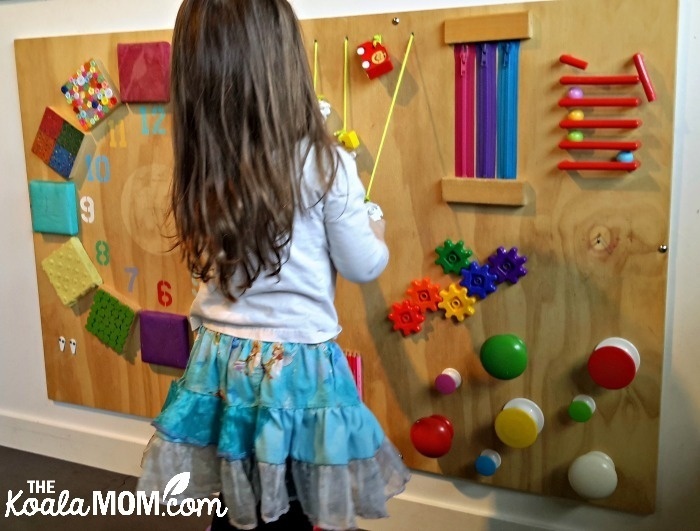 Indoor places to play in Vancouver - Child playing with activity wall at Circus Play Cafe