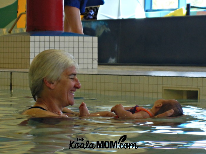 Woman holding baby at swimming pool