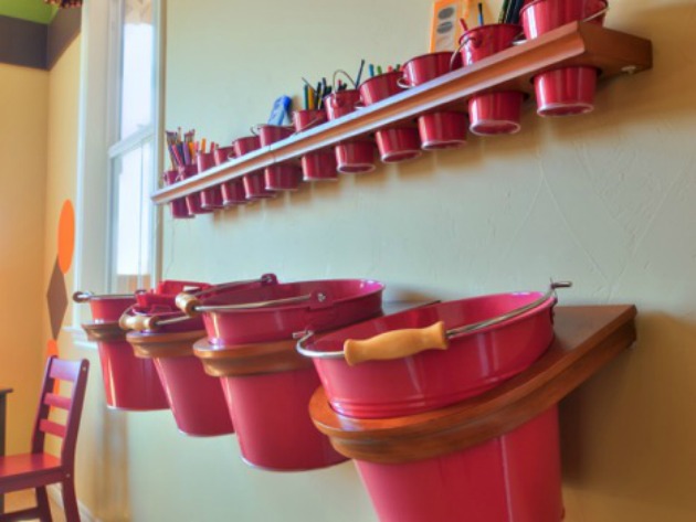 Pails hanging on wall to organize children's toys and art supplies