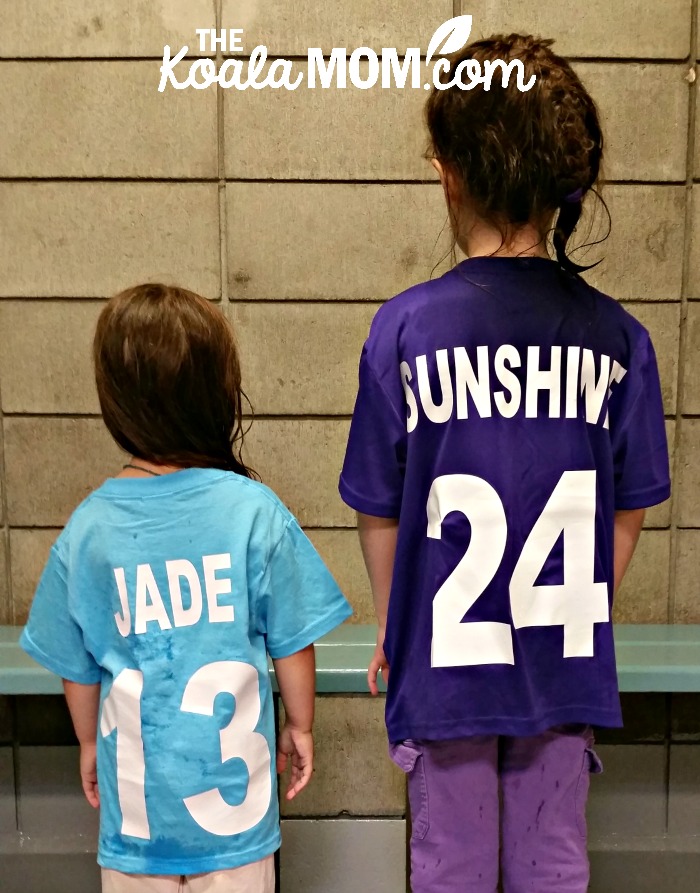 Two girls in a change room wearing sports team jerseys