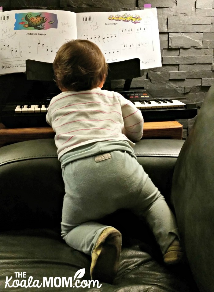 Baby playing keyboard while wearing Kooshoo pants