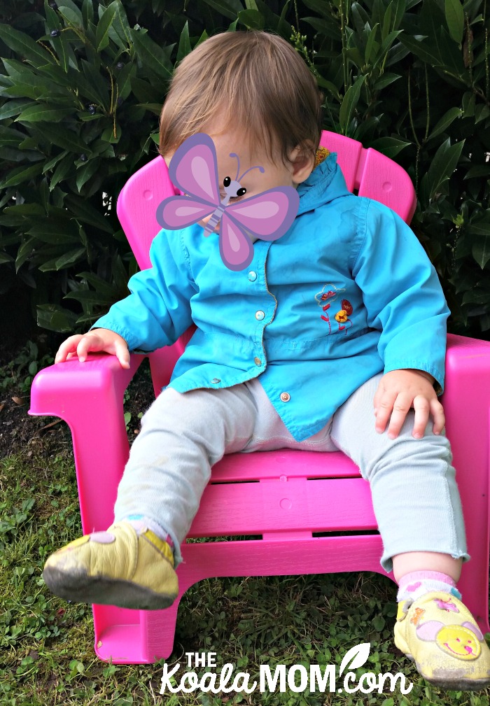 Baby girl sitting in a hot pink lawn chair while wearing Kooshoo pants