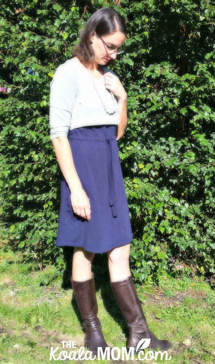 Mom wearing a blue-and-grey nursing dress from Momzelle with necklace from LouLou Lollipop and brown boots