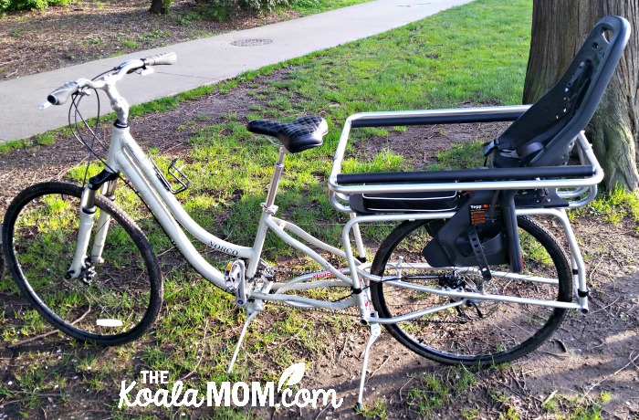 A cargo bike with baby seat on the back