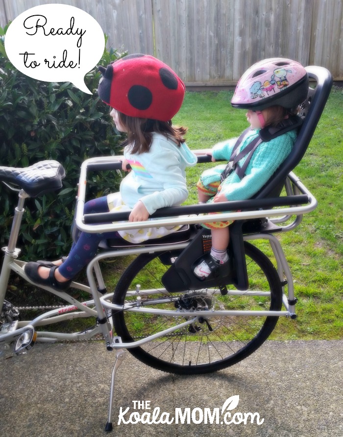 Toddler and a baby on the back of a cargo bike, ready to ride!