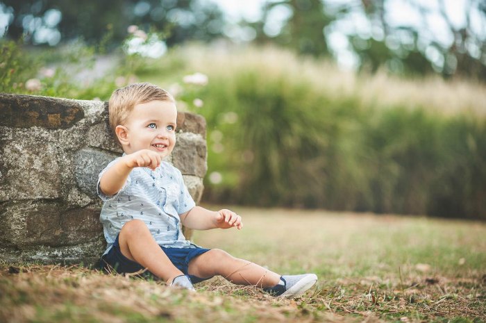 Smiling boy sitting on a path