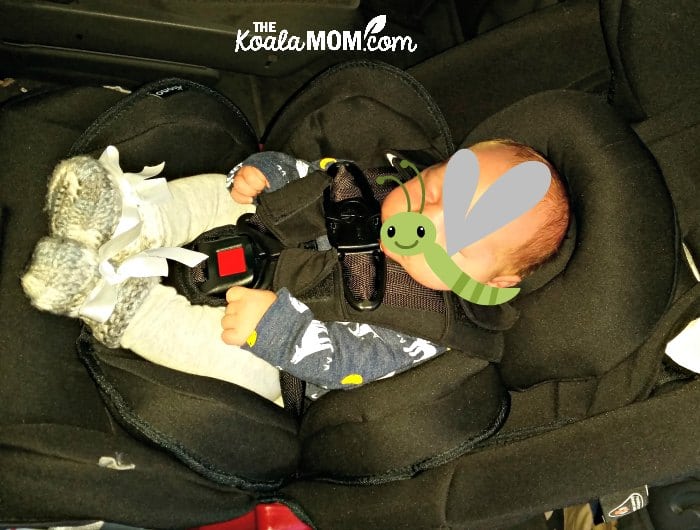 Infant sitting cozily in a Diono Radian car seat, supported by the infant cushions