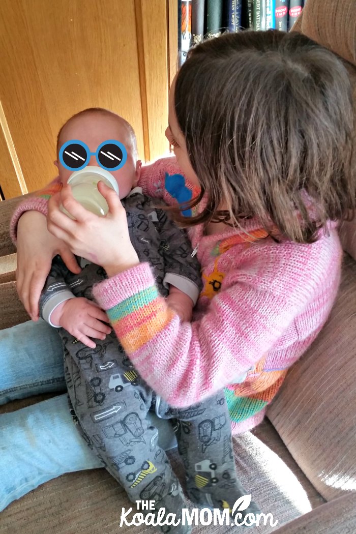 Big sister feeding her 2-month-old brother with the Nuk Simply Natural bottle
