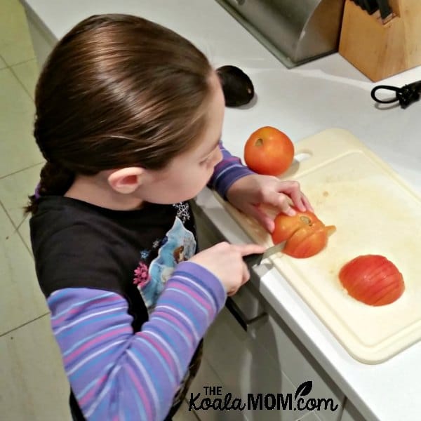 Sunshine slices tomatoes for tacos.