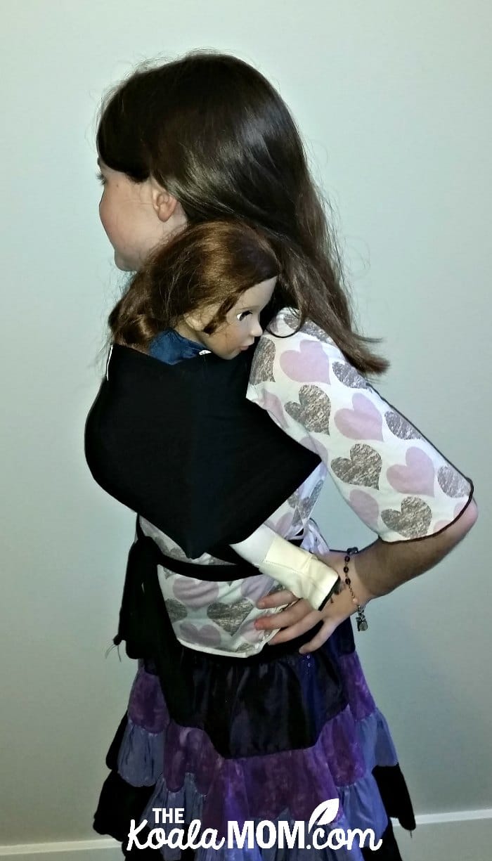 Nine-year-old girl wearing her 18-inch doll in a Beluga Baby bamboo doll wrap