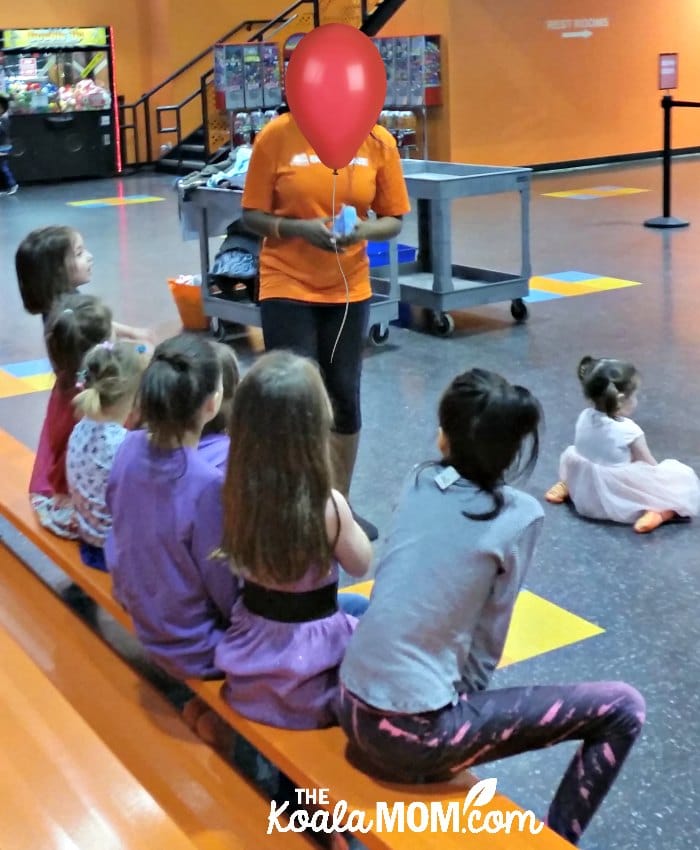 SkyZone staff member explains bouncing rules to a birthday party group.