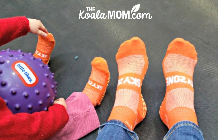 Mom and toddler wearing their orange SkyZone socks.