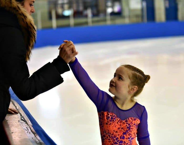 Six-year-old girl doing figure skating and giving her mom a high-five