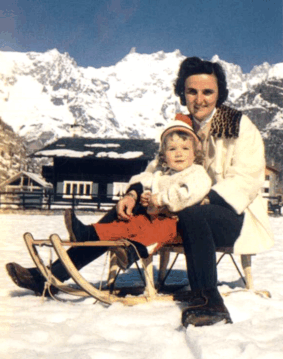 St. Gianna Beretta Molla with her daughter on a sled in the mountains.