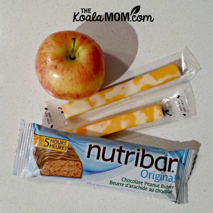Some healthy snacks - a Nutribar, apple, and cheese sticks