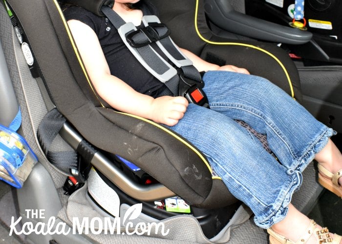 A close-up view of a toddler buckled in the Britax Emblem convertible car seat.