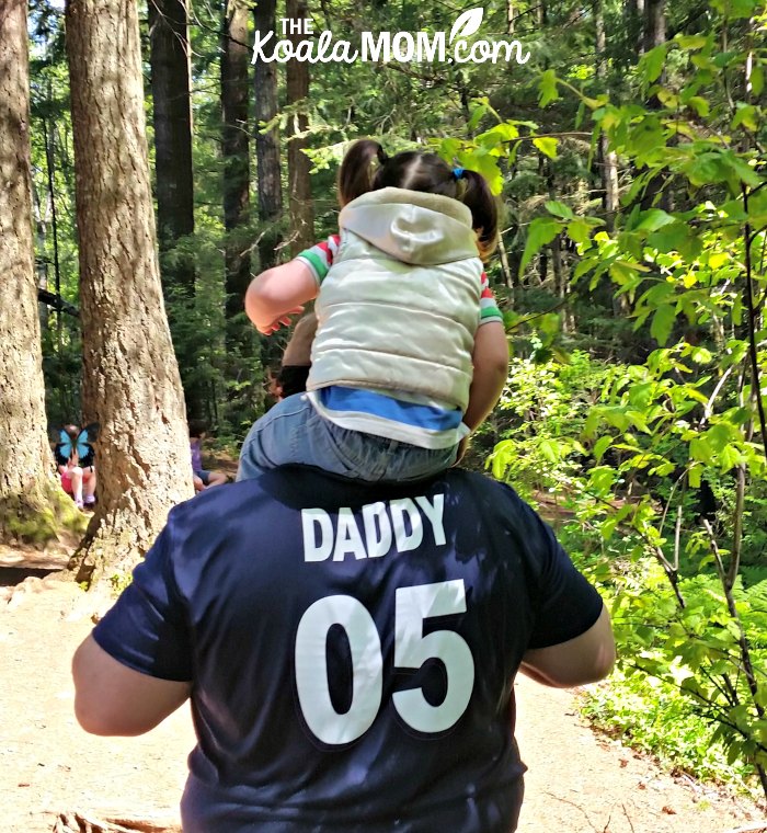 Daddy gives a toddler a shoulder ride.