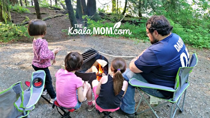 Daddy and daughters making s'mores over a fire at Cultus Lake Campground.