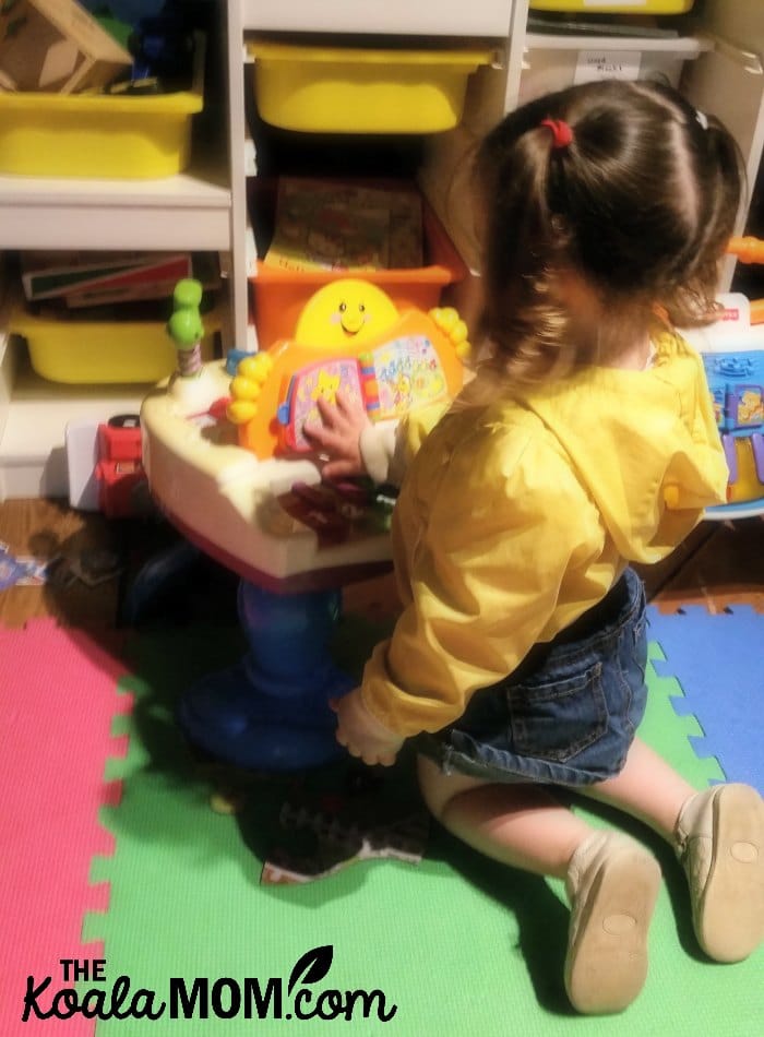 Toddler playing a toy piano in the kids' play area at the Blenheim Pub in the Kitsilano neighbourhood in Vancouver, BC.