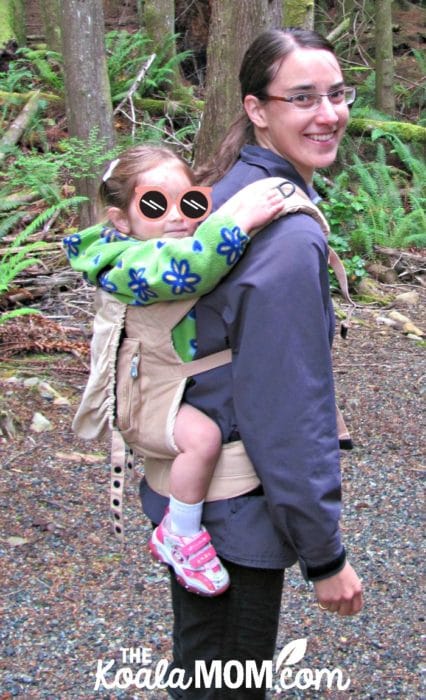 Mom carrying her toddler in an ErgoBaby original carrier; babywearing is part of attachment parenting.