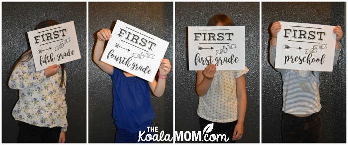 Four girls holding up their "first day of school" signs for back-to-school photos.