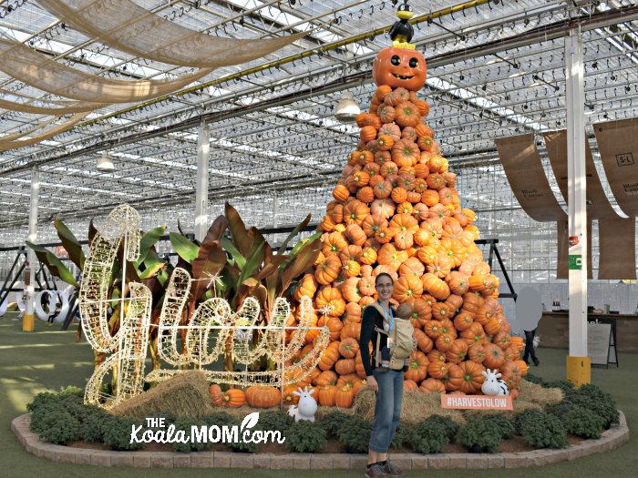 Bonnie Way posing beside the giant pumpkin pile at the entrance to Glow Harvest in Langley, BC.