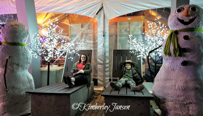 Mother and son relaxing on the giant loungers at the Vancouver Christmas Market during their mother-son date night.