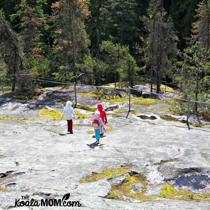 Three girls exploring the rocks near Nairn Falls.