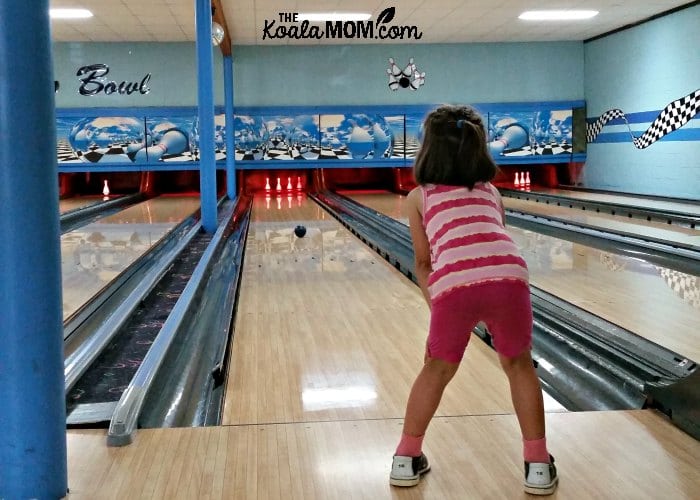 5-year-old watching her bowling ball roll down the lane.